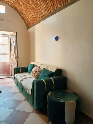 a living room with a green couch and a table at Nuba in Aswan
