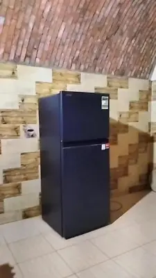 a black refrigerator in front of a wall of wood at Nuba in Aswan