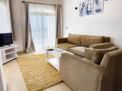 a living room with a couch and a tv at Stunning Nile view Apartment in Luxor