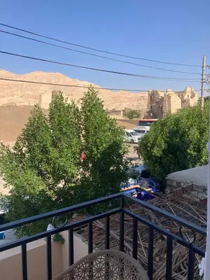 a balcony with a view of the desert and buildings at Habu House Luxor in Luxor