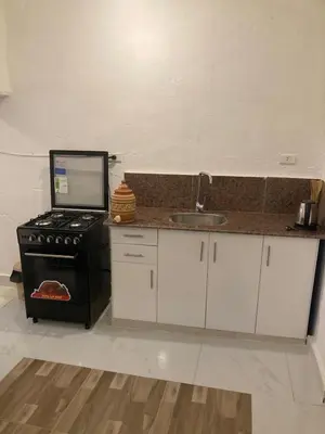 a small kitchen with a stove and a sink at Habu House Luxor in Luxor