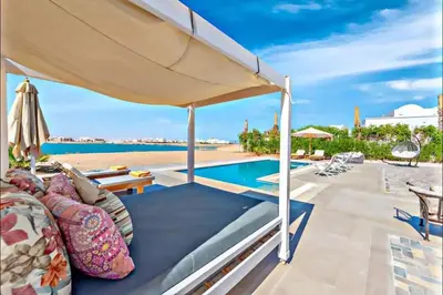 a patio with an umbrella and a swimming pool at Luxury villa in gouna in Hurghada