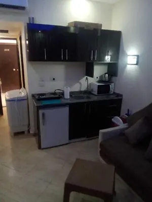 a kitchen with black cabinets and a counter top at Furnished Chalets for Rent in Cecilia Resort Furnteched, kitchenee, Near Airport in Hurghada