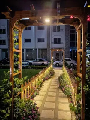 a garden walkway with a wooden arch in front of a building at Furnished Chalets for Rent in Cecilia Resort Furnteched, kitchenee, Near Airport in Hurghada