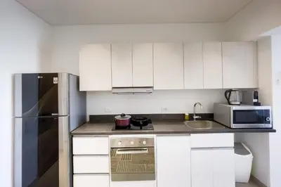 a kitchen with white cabinets and a stainless steel refrigerator at Prim & Pleasing 1BDR Kamaran El Gouna in Hurghada