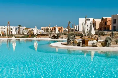 a large swimming pool in a resort with buildings at Prim & Pleasing 1BDR Kamaran El Gouna in Hurghada