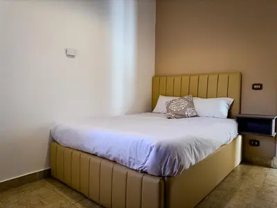 a bed with a wooden headboard in a room at Nile view Apartment in Luxor