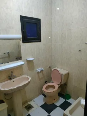 a bathroom with a toilet and a sink and a tv at Al Dahar apartments Hurghada in Hurghada