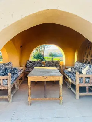 a table and two couches and a table and a table and chairs at Nubian House in Al Aqālitah