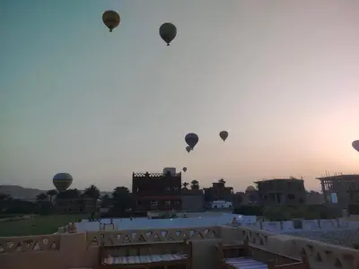 a group of hot air balloons flying in the sky at Nubian House in Al Aqālitah