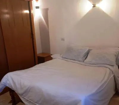 a bedroom with a white bed with a light on it at Upper Egypt House in Luxor