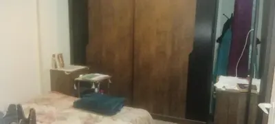 a bedroom with a bed and a wooden closet at شقه ب موقع متميز عل النيل in Naj‘ al ‘Amrāb