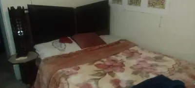 a small bedroom with a bed with a floral blanket at شقه ب موقع متميز عل النيل in Naj‘ al ‘Amrāb
