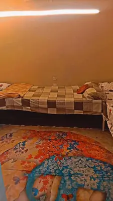 a bed in a room with a rug on the floor at وسط البلد البلدوزر بجوار مستشفي النيل التخصصي in Aswan