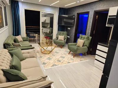 a living room with a couch and chairs and a television at قرية الهمبرا السياحية بالغردقة in Hurghada