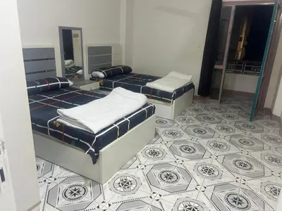 two beds in a room with a tiled floor at Dream apartment3 in Hurghada