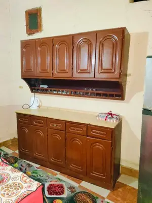 a kitchen with wooden cabinets and a counter top at Sunset Mirage in Luxor