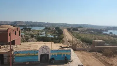 a building with a painting on it next to a river at Noury kato in Jazīrat ‘Awwāḑ