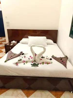 a bed with two swans made out of flowers at Noury kato in Jazīrat ‘Awwāḑ