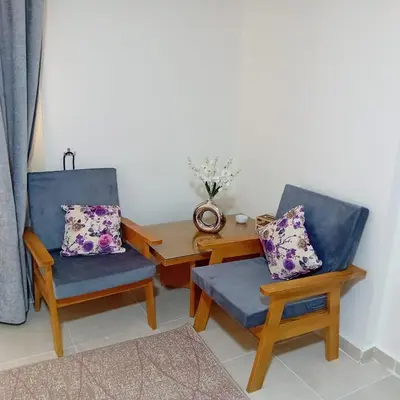 a living room with two chairs and a table at Tiba Golden -unit102 - Aladauy in Hurghada