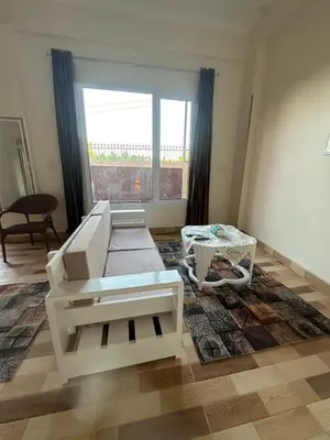 a living room with a white couch and a table at TibaHouse in Luxor