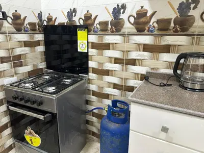 a kitchen with a stove and a shelf of vases at TibaHouse in Luxor