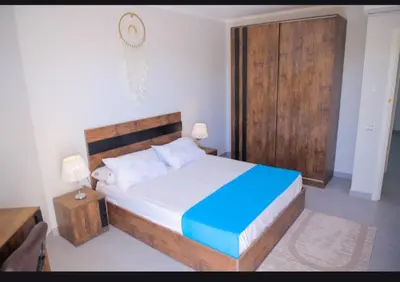 a bedroom with a large bed with a wooden headboard at Scandic Hurghada 323 in Hurghada