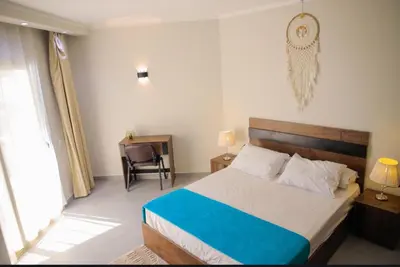 a bedroom with a bed and a desk with a chair at Scandic Hurghada 323 in Hurghada