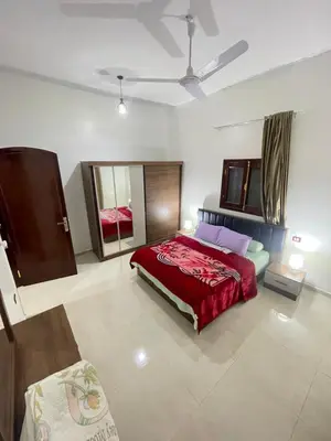 a bedroom with a large red bed in a room at Al-Fardous house in Luxor