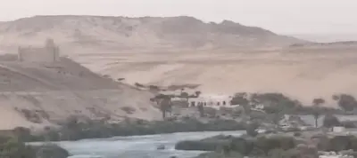 a painting of a town on a hill next to a river at Aswan Nile View Dreams in Aswan