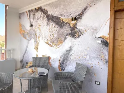 a room with a table and chairs and a painting at Aswan Nile View Dreams in Aswan