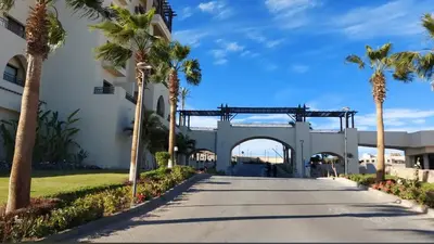 a walkway in front of a building with palm trees at شقه فندقية متكامله 1 غرفه غايه فى الروعه والهدوء hurghada in Hurghada