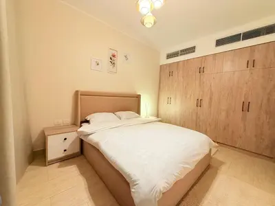 a bedroom with a large bed and a wooden cabinet at شقه فندقية متكامله 1 غرفه غايه فى الروعه والهدوء hurghada in Hurghada