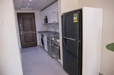 a kitchen with a black refrigerator and a dishwasher at Scandic Resort Hurghada in Hurghada