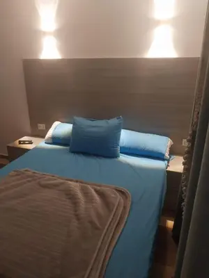 a bed with two blue pillows on top of it at Royal residence in Marsa Alam