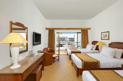 a hotel room with two beds and a television at Marlin Inn Azur Resort in Hurghada