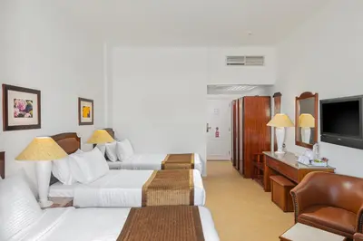 a hotel room with two beds and a flat screen tv at Marlin Inn Azur Resort in Hurghada