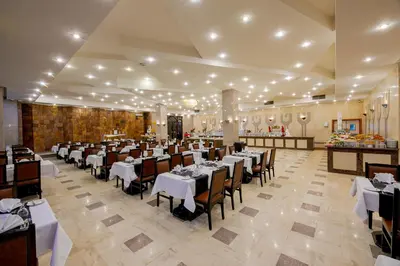 a restaurant with white tables and chairs in a room at Marlin Inn Azur Resort in Hurghada