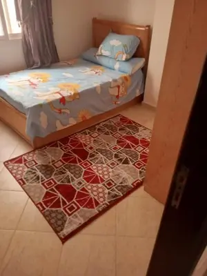 a bedroom with a bed and a rug on the floor at Eslam apartment 2 in Hurghada