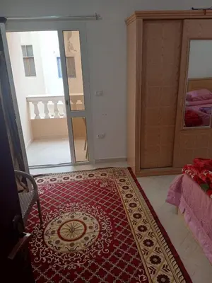 a room with a red rug on the floor next to a bedroom at Eslam apartment 2 in Hurghada