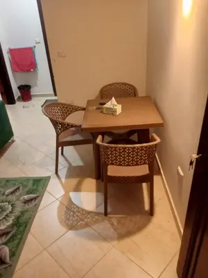 a wooden table and chairs in a room at Eslam Apartments in Hurghada