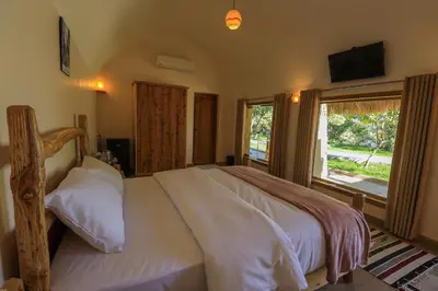 a bedroom with a large bed with a large window at Eden on the Nile in Luxor