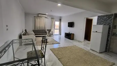 a living room with a white refrigerator and a couch at Paradise Hill in Hurghada