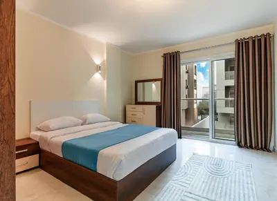 a bedroom with a bed and a large window at Luxury City Center One-Bedroom Suite by Peaks in Hurghada