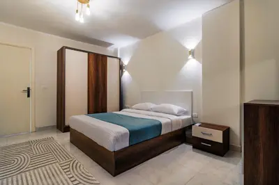 a bedroom with a bed with a blue blanket at Luxury City Center One-Bedroom Suite by Peaks in Hurghada