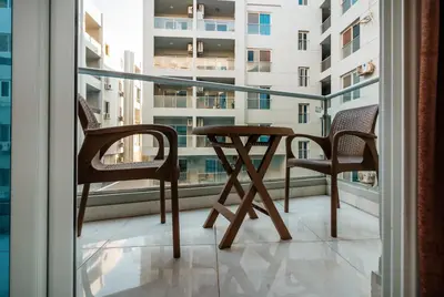 a table and two chairs on a balcony with a window at Luxury City Center One-Bedroom Suite by Peaks in Hurghada