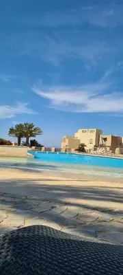 a view of a beach with a building in the background at Exklusives Apartment mit Dachterrasse und Meerblick in Hurghada