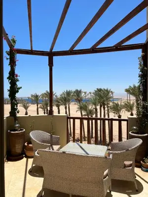 a patio with a table and chairs and a view of the beach at Exklusives Apartment mit Dachterrasse und Meerblick in Hurghada