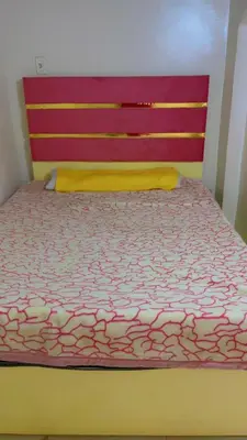 a bedroom with a bed with a red head board at the little house in Aswan