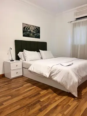 a bedroom with a large bed and a wooden floor at Touristic Center in Hurghada